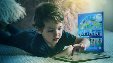 طفل يستخدم جهاز لوحي بينما يترك كتابًا تعليميًا بجانبه في مشهد يعكس هيمنة المحتوى الرقمي على تعلّم الأطفال